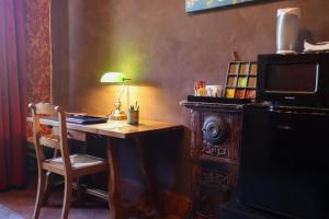 ein Schreibtisch mit Lampe und Stuhl in einem Zimmer in der Unterkunft Sonic Alchemy Studio BnB in Castel Focognano