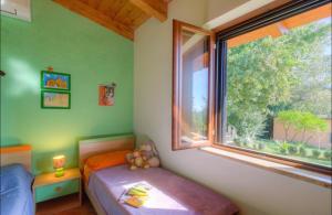 a small bedroom with a bed and a window at Villa Privata con Giardino e Piscina in Trivio
