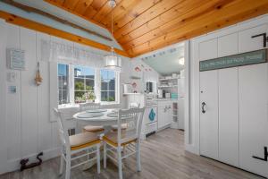 a kitchen with a table and chairs in a room at Seaglass Cottage – Where Calm Meets Tide in South Yarmouth