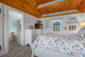 a bedroom with a bed and a bathroom at Seaglass Cottage – Where Calm Meets Tide in South Yarmouth
