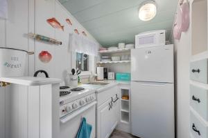 a kitchen with white appliances and a white refrigerator at Seaglass Cottage – Where Calm Meets Tide in South Yarmouth +25 photos