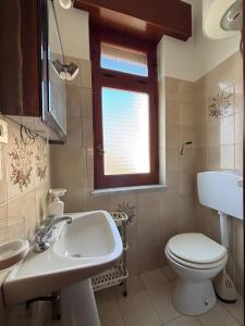 a bathroom with a sink and a toilet and a window at La casa di Caliddu in Torrenova +26 photos