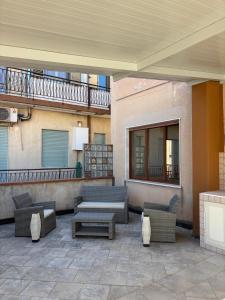 a patio with couches and tables on a building at La casa di Caliddu in Torrenova