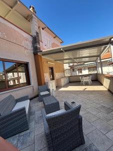 a patio with wicker chairs and a table and a table and chairs at La casa di Caliddu in Torrenova