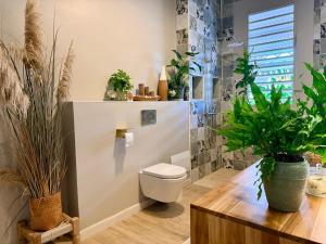 a bathroom with a toilet and lots of plants at Villa Chic à Petit-Havre in Le Gosier +52 photos