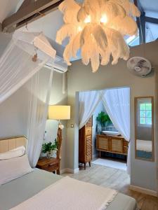a bedroom with a bed and a chandelier at Villa Chic à Petit-Havre in Le Gosier