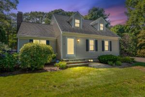 a house with a green lawn in front of it at On Cape Time – Family Friendly Relaxing Escape in Osterville