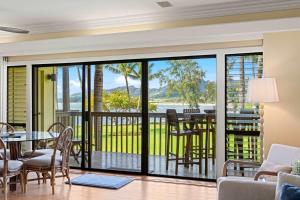 a living room with a balcony with a table and chairs at NEW Beachfront 2 Bedroom Ocean View Oasis and Pool in Kapaa