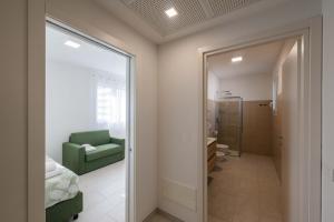 a bedroom with a green chair and a mirror at FEEL - Palazzo Ortelli in Bergamo +124 photos