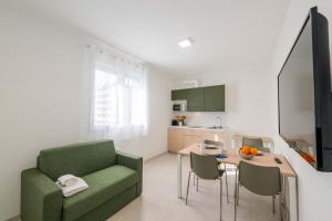 a living room with a green couch and a table at FEEL - Palazzo Ortelli in Bergamo