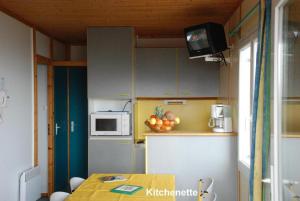 a small kitchen with a table and a microwave at Chalet Aster 1 in Blavignac