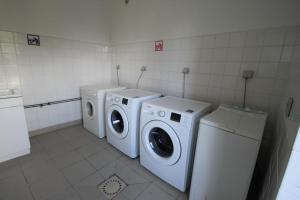 a laundry room with three washing machines and a washer and dryer at Chalet Aster 1 in Blavignac