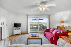 a living room with a red couch and a table at Peaceful Waterfront Cottage Escape in Eastham
