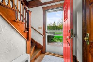 a hallway with a red door and a staircase at Peaceful Waterfront Cottage Escape in Eastham +34 photos