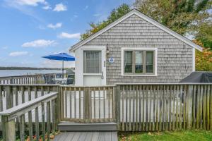a small house with a fence and an umbrella at Peaceful Covefront Cottage Retreat in Eastham in Eastham +33 photos
