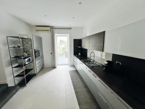 a kitchen with black and white cabinets and a white floor at AragonApartment in Santa Maria a Vico