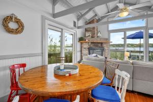a living room with a wooden table and chairs at Charming Waterfront Escape Along the Cove in Eastham