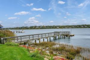 a dock on a lake with boats in the water at Tranquil Eastham Waterfront Cottage Escape in Eastham