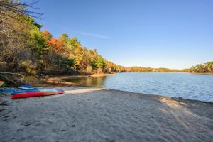 a beach with two kayaks on the shore of a lake at Peaceful Cape Cod Escape with Pond Views Hot Tub in Sandwich