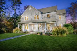 a gray house with a lawn in front of it at Peaceful Cape Cod Escape with Pond Views Hot Tub in Sandwich +55 photos