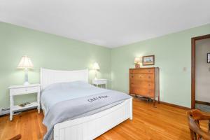 a bedroom with a white bed and a wooden floor at Spacious Dog-Friendly Retreat in Chatham in Chatham