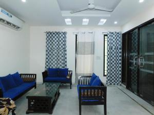 a living room with blue couches and a table at Home By The Park in New Delhi