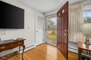 a room with a door with a television and a desk at Cozy Cape Escape Near Beaches Dining in Centerville