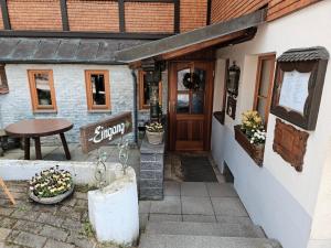 a restaurant entrance with a table and a wooden door at Bürgerstüble in Sankt Peter