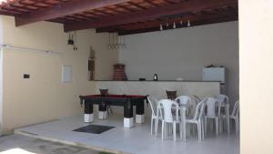 a ping pong table and white chairs in a room at Cantinho do sol in Maceió