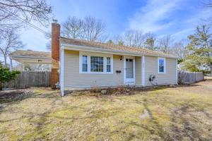 a white house with a brick chimney on a yard at Dog-Friendly Cape Cod Getaway with Fire Pit Yard in South Yarmouth