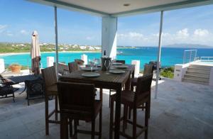 a dining room table with chairs and a view of the ocean at Spectacular views in Long Path