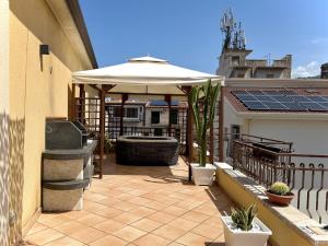 a patio with an umbrella and a fountain on a building at Luxury Domus Apartment in SantʼAgata di Militello