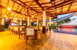 a dining area with tables and chairs in a restaurant at Owinmo Hotel & reception Hall in Galle