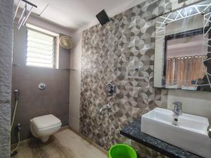 a bathroom with a sink and a toilet and a mirror at Star Spandan in New Town +7 photos