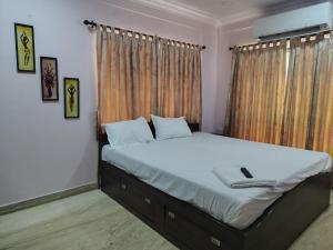 a bedroom with a bed with white sheets and a window at Star Spandan in New Town