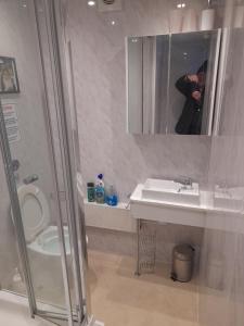 a person taking a picture of a bathroom with a toilet and sink at The Bolt Hole in Barmouth