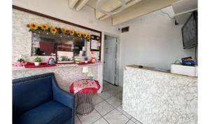 a waiting room with a blue couch and a mirror at Anhinga Motel Homestead FL in Homestead
