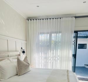 a bedroom with a white bed and a window at 15 On Candy in Midrand