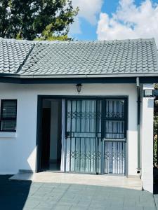a white house with a large glass door at 15 On Candy in Midrand