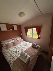 a bedroom with a large bed with two towels on it at Withernsea sands-Maple grove in Waxholme +15 photos