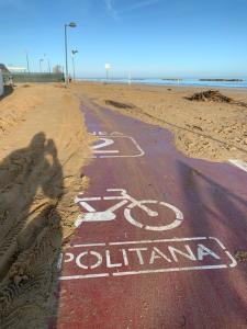 a bike lane on a beach next to the ocean at Sassonia beach in Fano
