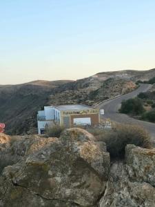 a building on the side of a mountain with a road at Résidence Arinas in Al Barāwikah
