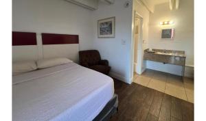a bedroom with a bed and a bathroom with a sink at Anhinga Motel Homestead FL in Homestead