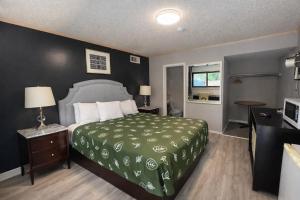a hotel room with a bed with a green bedspread at Motel Edgebrook Chicago North Shore By Oyo in Chicago