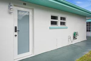 a white house with a door and a green roof at Naples Triplex Retreat in Naples