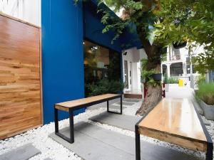 a wooden bench sitting in front of a building at Shade House - Bitec Bangna in Bangkok