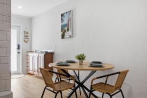 a dining room table with two chairs and a table at Naples Triplex Retreat in Naples