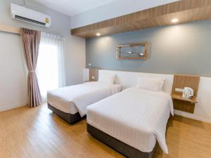 a hotel room with two beds and a window at Shade House - Bitec Bangna in Bangkok