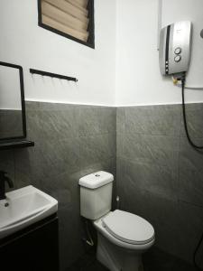 a bathroom with a white toilet and a sink at Homestay Idora PD in Port Dickson