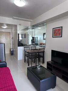 a living room with a table and chairs and a kitchen at SMDC Tagaytay Condominium in Kaybagal